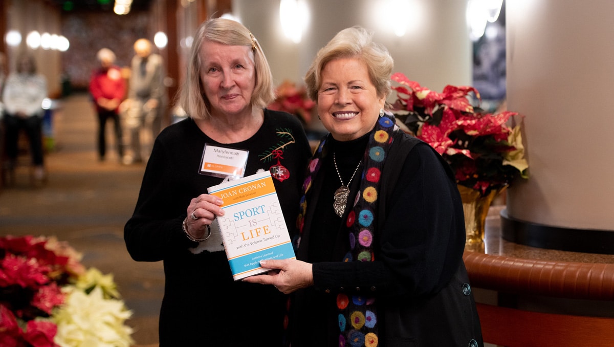 Joan Cronan poses with a holiday reception attendee