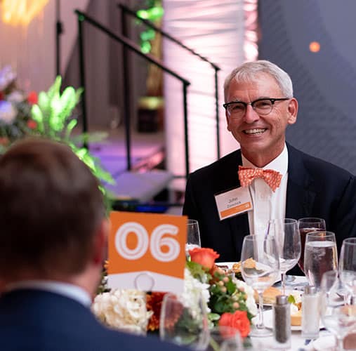 A man seated at a table during the Alumni Awards Gala