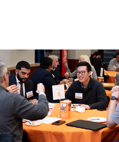 Alumni sitting at a table during a networking event