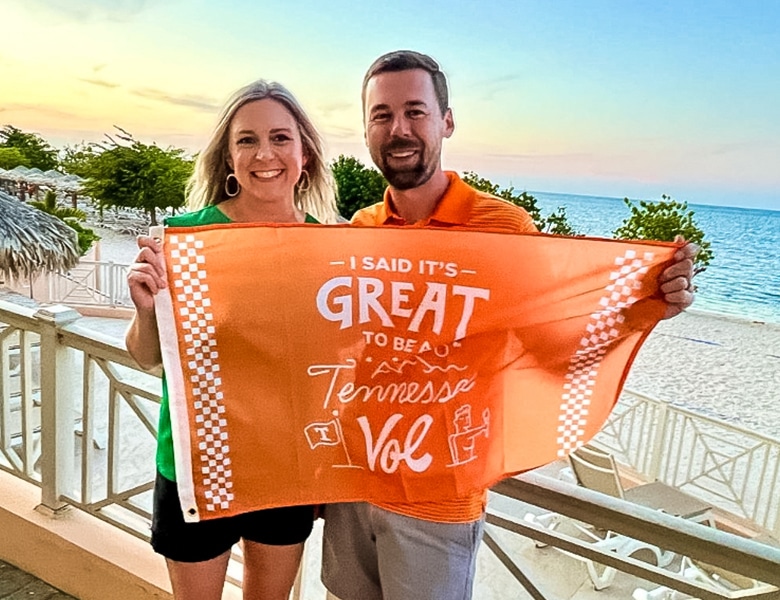 An alumna and alumnus hold a Tennessee Volunteers flag