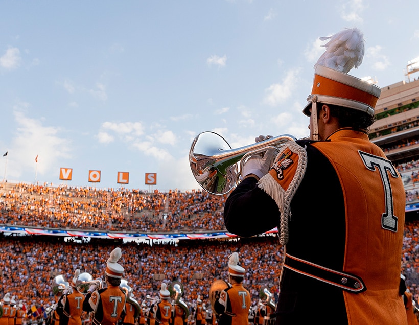 Pride of the Southland Band on the field in Neyland Stadium with the V-O-L-S letters in the background