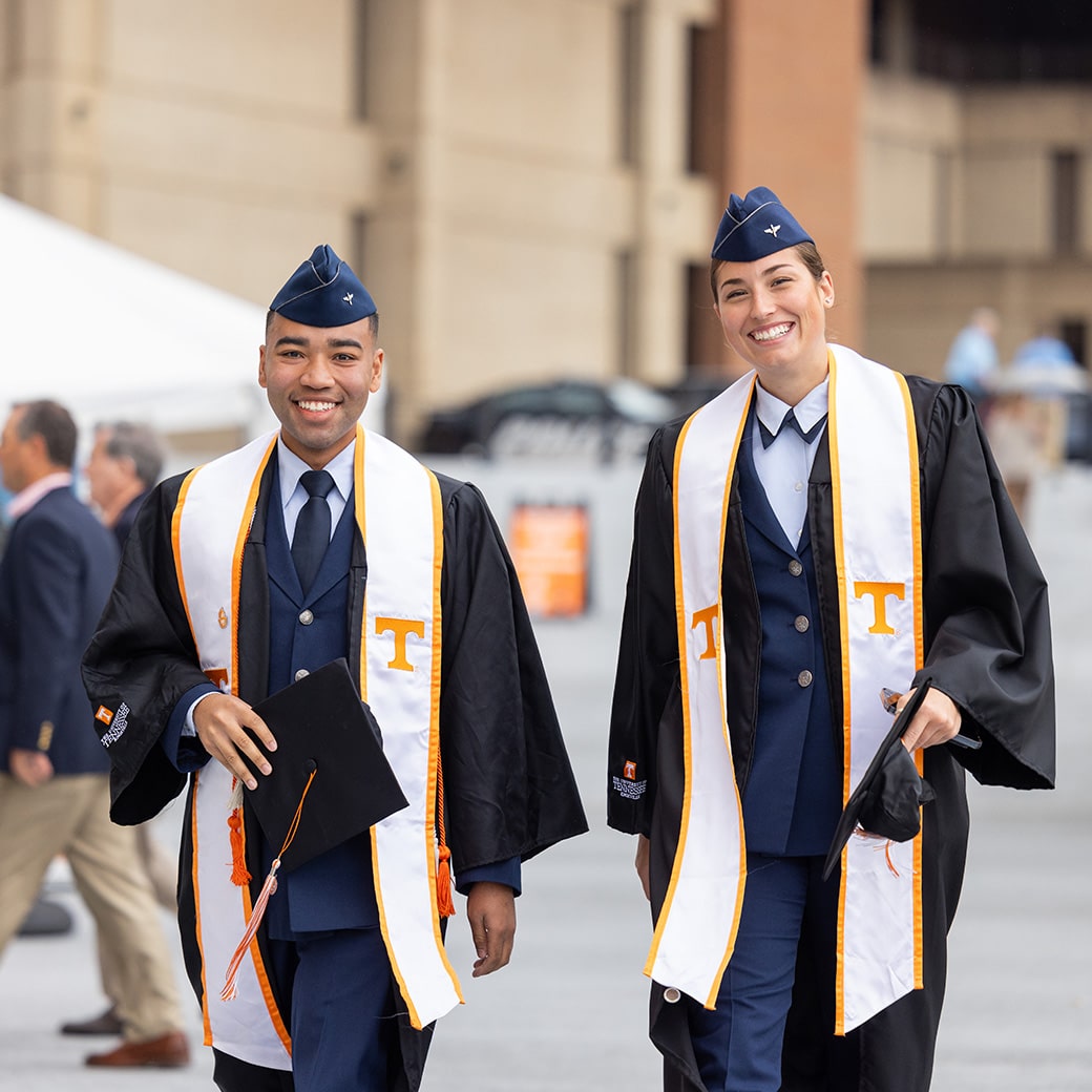 Two Air Force ROTC members in commencement regalia
