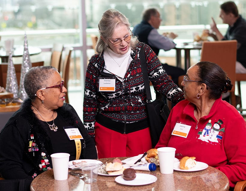 3 UT retirees chat during the annual holiday party