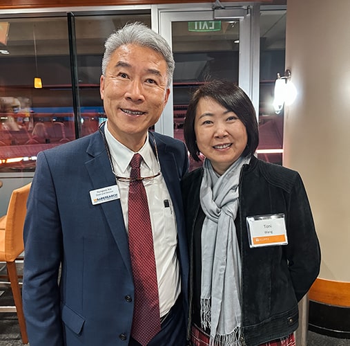 An alumnus takes a photo with Dean Xin 