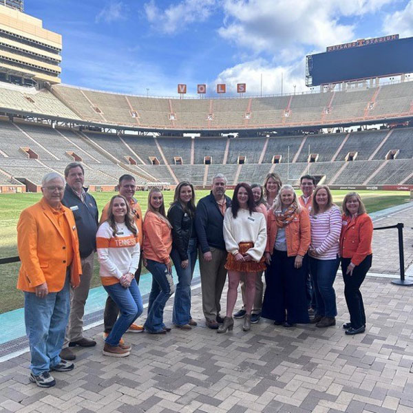 A group of Knoxville alumni pose for a photo in Neyland Stadium during the annual Knoxville Tipoff BBQ