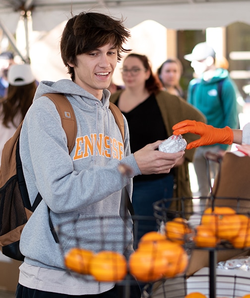 A student holding a free biscuit during Welcome Wednesday
