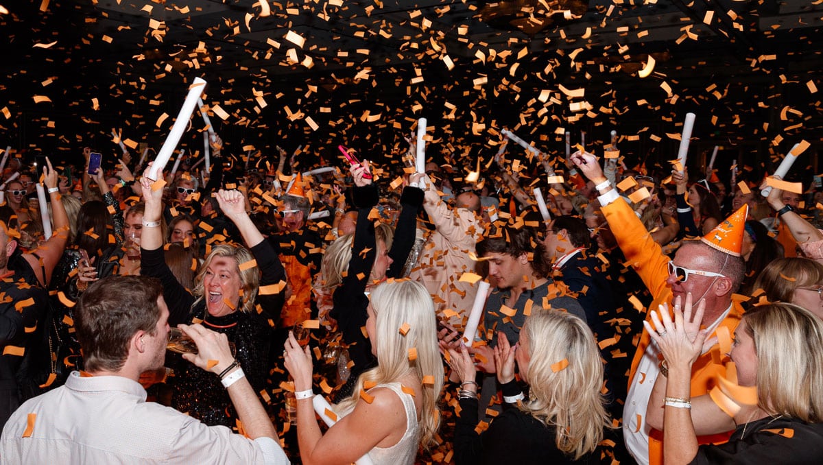 Alumni celebrate with orange confetti on New Year's Eve 2023