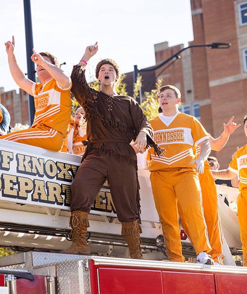 Davy Crockett and members of the UT Spirit Team on a firetruck during the Homecoming parade