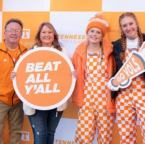 A family of 4 poses for a photo during the Homecoming tailgate