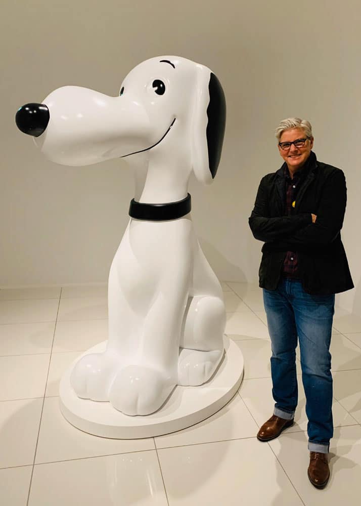 braddock-paige-and-snoopy-714x1000 Paige Braddock stands to the right of a large Snoopy sculpture.