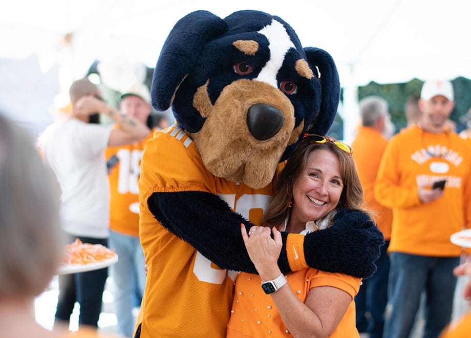 hero-tailgate-smokey-fan-920x660 Smokey the mascot hugs a fan during a tailgate event.