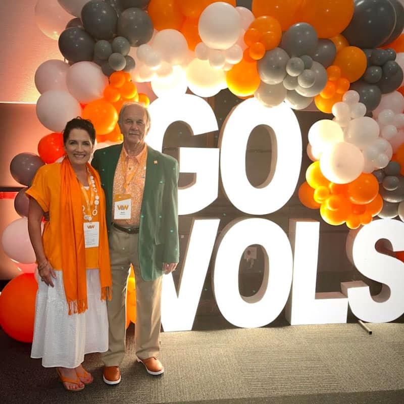 vantrease-jana-and-jerry-go-vols-800x800 Jana Vantrease and Jerry Vantrease pose for a photo in front of an orange-and-white balloon arch and lighted letters that say Go Vols.