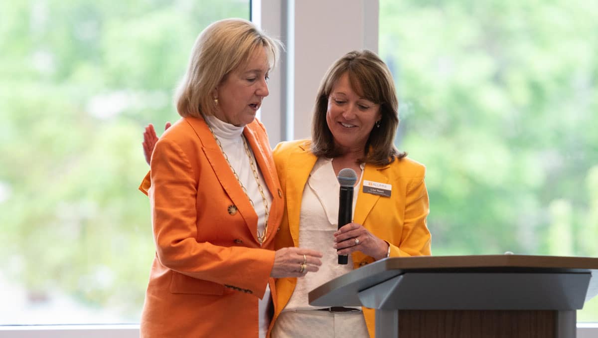 chancellor-plowman-and-lisa-reed-1200x678 Lisa Reed hands a microphone to Chancellor Donde Plowman.
