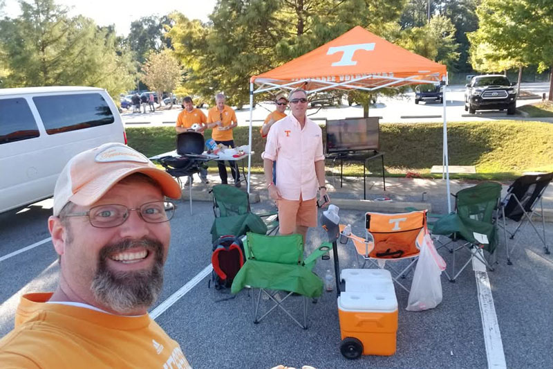 One person takes a selfie during a tailgate.