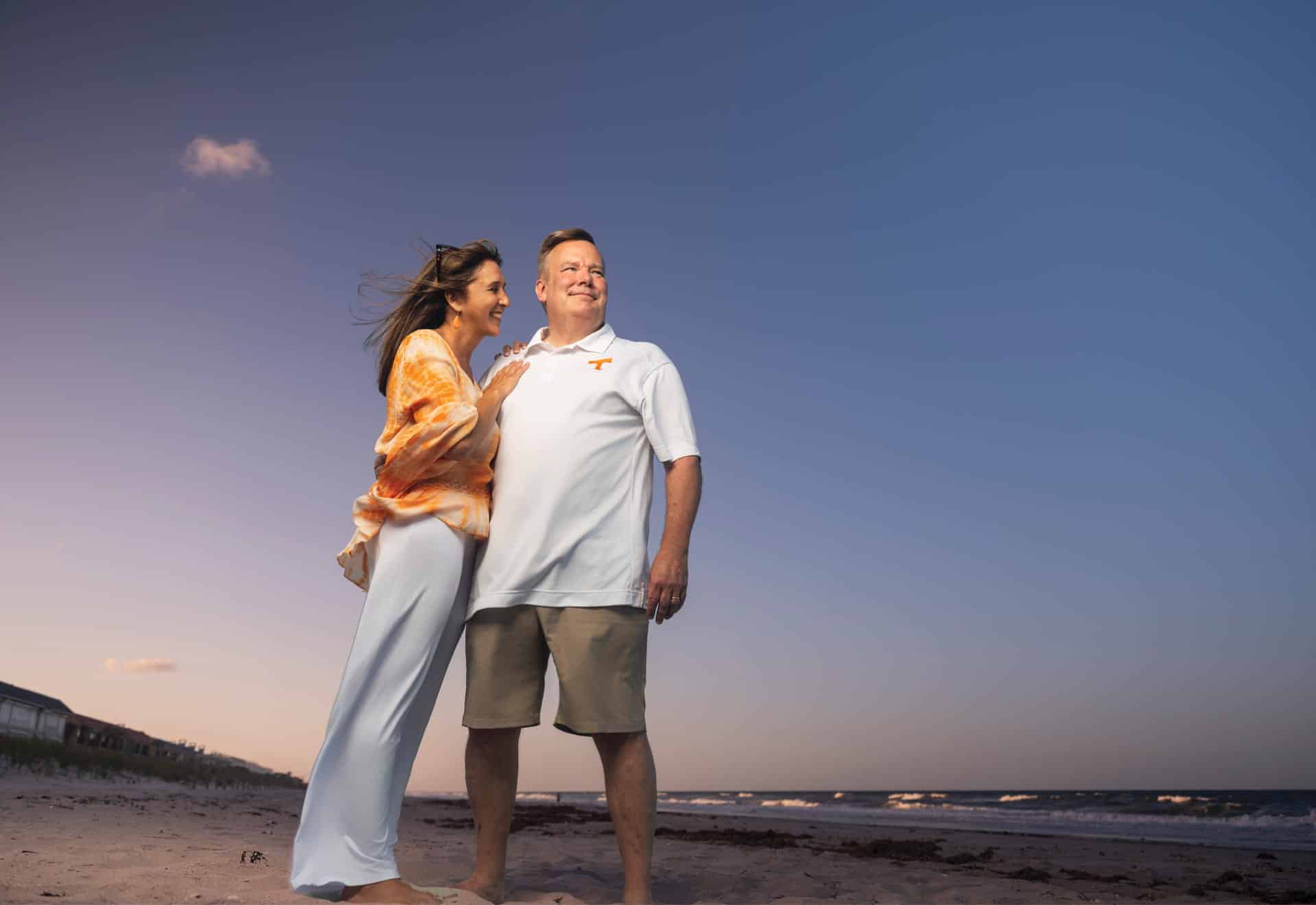 Jeff Abbott standing on the beach with his wife