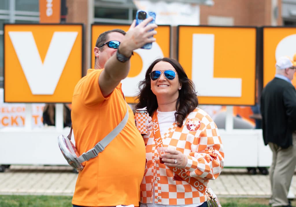 Vols fans taking a selfie in front of a V O L S sign