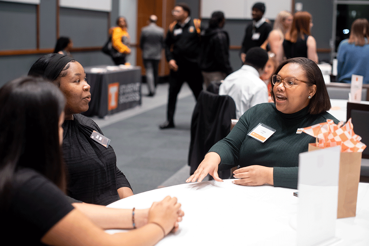 People talking at a table and smiling