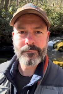 Person in forest poses for a selfie
