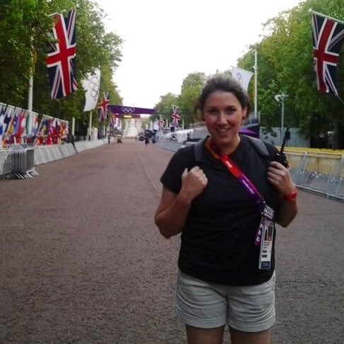 Stephanie Jones at the london olympics standing in the street smiling with flags in the background