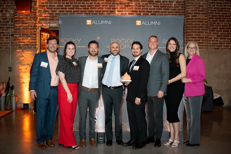 eight people standing together at the rocky top business awards for UT alumni